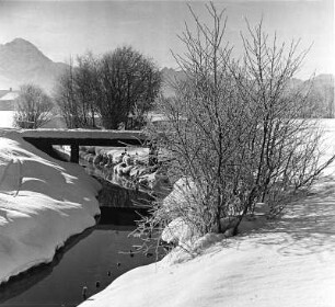 Winterbilder. Bachlauf mit hölzernem Steg im Schnee (vielleicht bei Sonthofen)