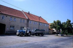 Bauernhäuser; Gebäude der ehemaligen LPG-Verwaltung; Traktor mit Hänger auf Freifläche