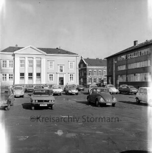 Hagenstraße: vorne parkende Pkws, im Hintergrund das Rathaus, rechts das Stadthaus: Blick von Nordosten