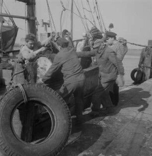 Stralsund. Fischereihafen, Fischer beim Be- oder Entladen eines Bootes