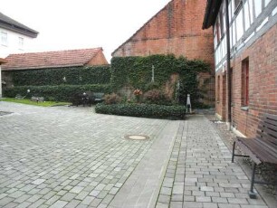 Kirchhof im Nordwesten mit angrenzenden Häusern (Rets der einst festen Kirchhofmauer stark überwachsen)