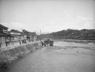 Wasserlauf in Kanazawa : Ansicht mit Geschäftsstraße am linken Ufer, Wehr und Anglern am rechten Ufer