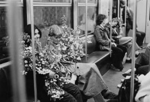 Frauen mit Blütenzweigen in einer U-Bahn