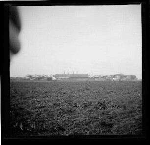 Bei Vendin-le-Vieil und Wingles (Dep. Pas-de-Calais, Frankreich): "Eisenwerk Altvendin bei Wingles (Gesamtansicht)", im Vordergrund ein Feld (Distanzaufnahme)