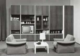 Anbauwand "Poel" : Wohnzimmermöbel. Anbauwand "Poel" (1976; Möbelkombinat Nord (MKN)). Ansicht mit zwei Sesseln und Couchtisch