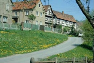abfallende Straße im Ort, oben Häuser, Fachwerk