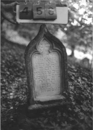 Grabstein 456 (Index: 99800215) Material: Sandstein Zustand: stark verwittert Maße HxBxT: 62x29x17 cm Beschreibung: Stele, Kielbogenabschluß, Schriftfeld eingetieft in Maßwerkform, Sockel: Grabstein 456