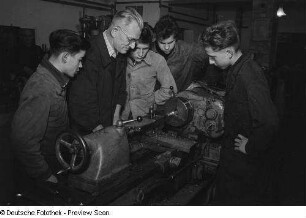 Auszubildende und Lehrkraft der Berufsschule Döbeln an einer Maschine