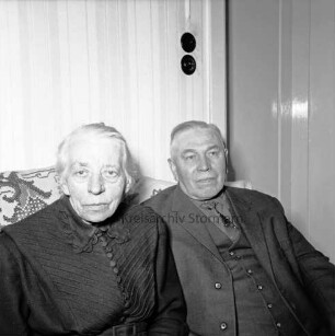 Hafemann, Gustav und Frieda, geborene Voß: Gustav geboren 1889: Eigentümer der Ziegelei in Westerau; ehemaliger Amtswehrführer des Amtes Reinfeld-Land: Einwohner von Westerau: Aufnahme aus Anlass ihrer Goldenen Hochzeit am 26. Februar 1965: in ihrer Privatwohnung, auf Sofa