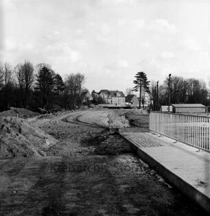 Konrad-Adenauer-Ring: Baustelle der Fußgängerunterführung, rechts der Sportplatz am Exer, im Hintergrund die Travebrücke: Blick nach Westen