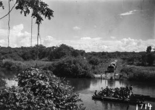 Personen auf einer Fähre : Am rechten Ufer Wagen der Expedition, in der Mitte des Flusses ein Floß mit vielen Personen