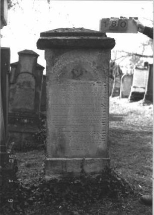 Grabstein 180 (Index: 99786058) Zustand: oberster Teil der Inschrift abgeblättert Maße HxBxT: 154x65x40 cm Besonderheit: kulturhistorisch wertvoll / künstl.-formale Gründe (Inschrift): Grabstein 180