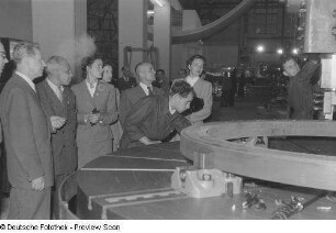 Messebesucher an einem technischen Ausstellungsobjekt (Fräsmaschine)