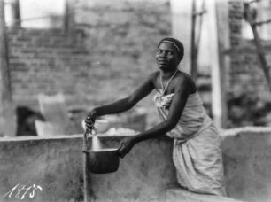 Eine Frau : Eine Frau holt mit einem Topf Wasser