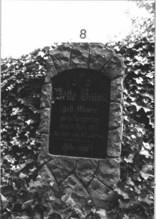Grabstein 8 (Index: 99805214) Material: Granit, schwarze Marmorplatte Zustand: Platte mehrfach gesprungen Maße HxBxT: 115x44x20 cm Beschreibung: Stele, rustica, Segmentbogenabschluß, Schriftplatte: Grabstein 8