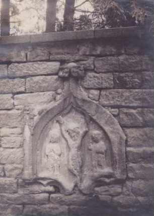 Spätgotische Kreuzigungszene in einer Nische an der alten Mauer des Friedhofes