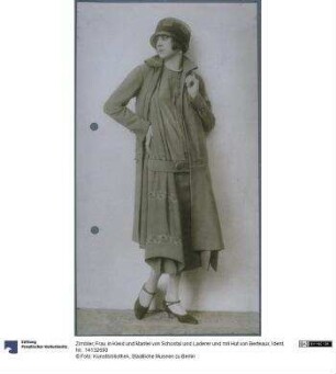 Frau in Kleid und Mantel von Schostal und Laderer und mit Hut von Berteaux