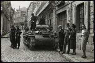 Deutsche Soldaten mit Panzer und Zivilisten in einer französischen Stadt