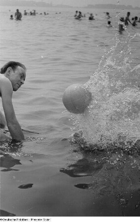 Mann im Wasser, mit einem Ball spielend