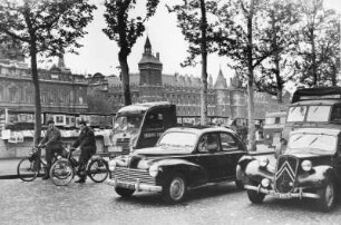 Paris. Ein kleiner Markt am Ufer der Seine.. In kleinen Ständen werden Kunst und Bücher angeboten. Im Vordergrund Autoverkehr