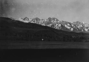 Gebirgszug : Panorama einer Ebene vor einem schneebedeckten Gebirgszug im Tian Shan Hochgebirge