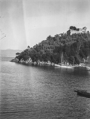 Seeblick : Blick auf einen See mit einem Segelboot. Auf einem Hügel oberhalb eine kleine Burg
