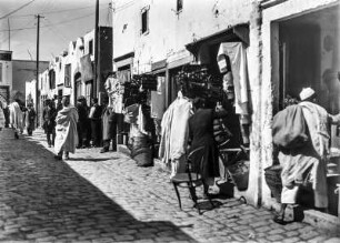 Gasse mit Läden : Blick durch eine Gasse, welche durch Läden gesäumt ist.
