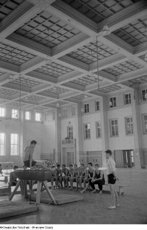 Turner während einer Übung am Seitpferd in einer Sporthalle der Deutschen Hochschule für Körperkultur in Leipzig