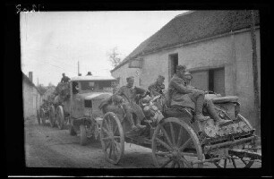 Crugny (?) (Dep. Marne, Frankreich): Soldaten auf einem Anhänger, im Hintergrund ein Lastkraftwagen auf einer unbefestigten Ortsstraße