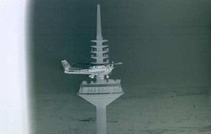 Frankfurt - Kleinflugzeug am Fernsehturm : Ein Kleinflugzeug fliegt unmittelbar am Fernsehturm vorbei. Aufgenommen in Frankfurt ca. 1985