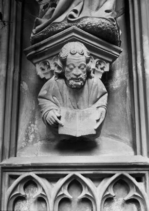 Figur mit aufgeschlagenem Buch