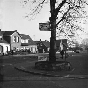 Möllner Landstraße: vorn Baum mit Hinweisschild zur Gaststätte Behn: darunter Hinweisschild zur Hausvermietung: rechts dahinter Mann: hinten links Ein- und Mehrfamilienhäuser: hinten rechts Wohnblock: davor Pkw