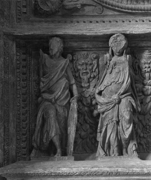 Relief zweier Figuren unter einem Medaillon
