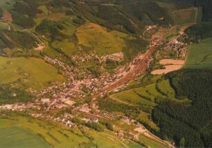 Probstzella. Ortsansicht im Loquitztal mit Bahnhof (bis 1990 Grenzbahnhof) und Eisenbahnstrecken nach Saalfeld (links), Gräfenthal (rechts) und Nürnberg (hinten, Grenzsicherungsanlage). Luftbild-Schrägaufnahme von Westnordwesten