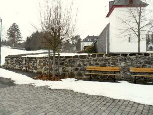 Ansicht von Ostsüdosten mit Kirche (Kirchturm Frühgotisch) über Kirchhofmauer (Wehrgang mit Steinbrüstung im 18 Jh abgetragen) im Verlauf nach Süden