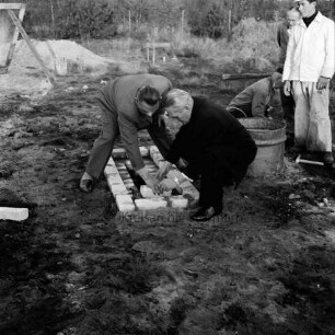 Friedhof Glashütte: Grundsteinlegung der Friedhofskapelle: Bürgermeister Hans Bombeck mauert Steine im Grundstein ein