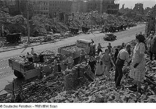 Dresden. Einwohner beim Bergen wiederverwendbarer Ziegel aus einem Trümmerberg und Verladen auf Lastkraftwagen bzw. Stapeln