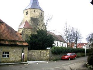 Ansicht von Nordosten mit Kirche (im Kern Romansich) über einst fester Kirchhofmauer (Wehrgang mit Steinbrüstung und hölzernen Komponenten im 18 Jh abgetragen)