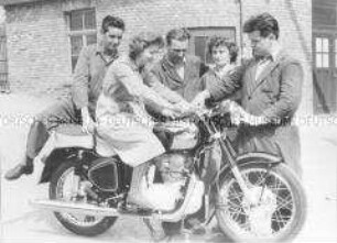 Gruppe von Arbeitern mit einem Motorrad