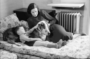 Bukarest: Haus des + Schriftleiters Wilhelm Müller, Frau Müller mit Junge und Hund auf Sofa, liegend
