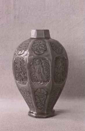 Achteckige, bauchige, eiförmige Vase mit eingepressten Bildfeldern mit Blüten und Gestalten