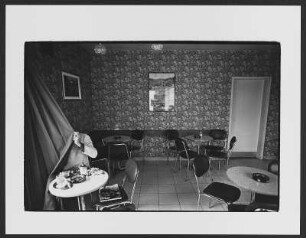 Café : Mann mit Stern-Magazin in einem New Yorker Café sitzend, einen Vorhang vor das Gesicht haltend