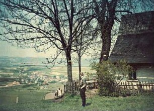 Blick ins Tal auf eine Ortschaft von einem Haus mit Bäumen