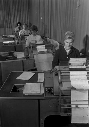 Frauen an Buchungsmaschinen in einem Großraumbüro