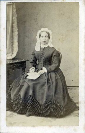 Fotografie einer sitzenden Dame mit Haube