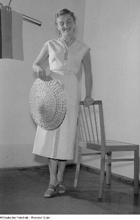 Eine Frau posiert mit Sommerkleid und Hut bei der "Internationalen Messemodenschau", Herbstmesse 1953