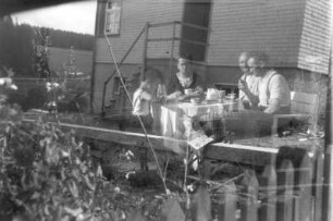 Ramon-Joachim Gerhardt mit seinem Vater Ernst Otto und zwei Verwandten beim Frühstücken im Freien