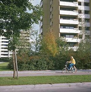 Hansjakob, Gottfried; München - Neuperlach Nord, Nord-Ost; Wohnanlage mit Ladenzentrum an der Quiddestraße - Grünanlage (von der Straße aus gesehen), Person auf Fahrrad unbekannt