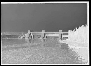 Staustufe Knetzgau. Wehr vom Unterwasser mit den hochgefahrenen Verschlüssen; rechts Umspundung für die Kraftwerksbaugrube. Schweinfurter Pegel = 50 cm.