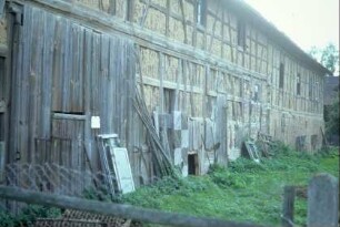 Rückansicht einer großen, langgestreckten Fachwerkscheune; Staken und Lehm